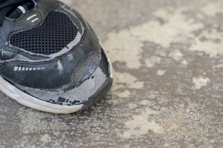 Top view broken old black canvas shoes on the floor. copy spaceの写真素材