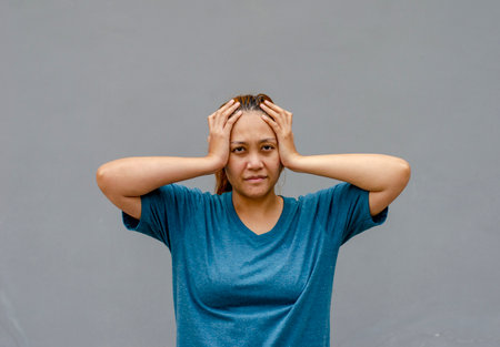 Asian women touch their temples, feel a headache or dizzy, feeling tired. need painkillersの写真素材