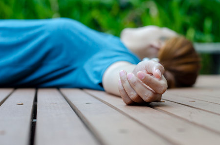 Hands of a young woman fainting in the park in the summer because of the hot weather.の写真素材