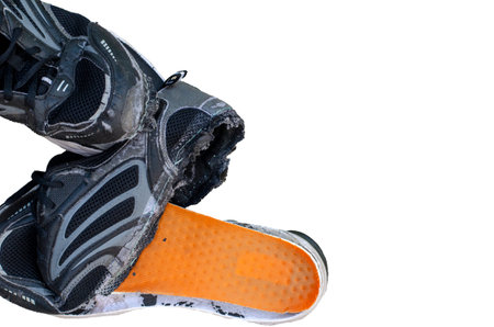 Torn old black shoes isolated on white background with clipping pathの写真素材