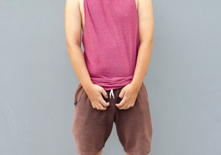 Asian man scratching itch with hand on genital area, health care conceptの写真素材