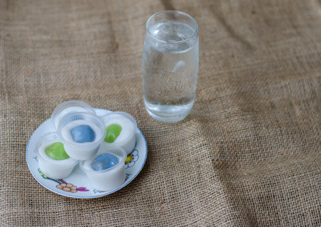 Homemade Steamed Flour with Coconut Filling little cup and drinking water. Thai call Khanom Sai Sai. Applied ancient Thai desserts. with copy space