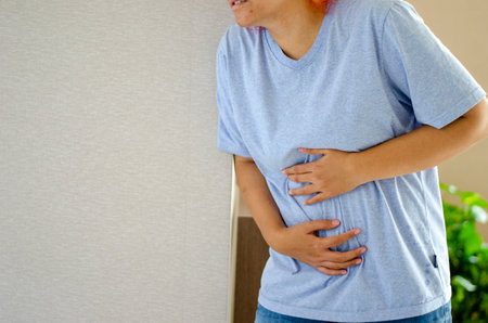 Young Asian woman has severe abdominal pain such as gastritis. Menstrual cramps Inflammation and...