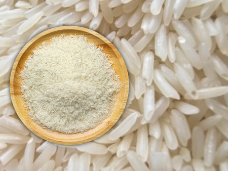Top view, jasmine rice grain on wooden plate with rice grain backgroundの写真素材