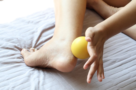 Achilles tendonitis. Use a massage ball on your ankle or foot to relieve pain. foot wellness conceptの写真素材