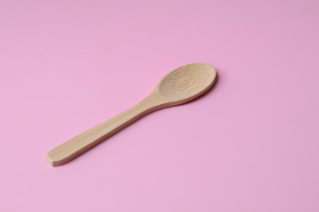 Side view one wooden Spoon on pink backgroundの写真素材