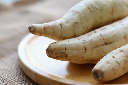 Closeup Kuri Kogane Japanese Sweet Potato on a wooden tray. Uncookingの写真素材
