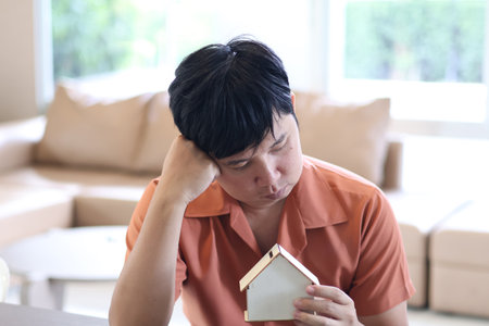 Asian man is stressed out over home debt problemsの写真素材