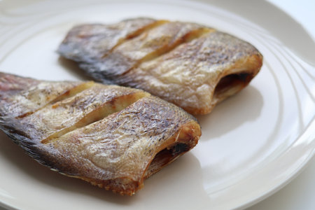 Close up view of Crispy fried gourami on a plate is a delicious Thai dish. Thai people like to use...