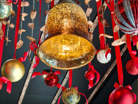 Christmas themed decorations featuring bell-shaped lanterns hangs in the ceiling and a variety of...