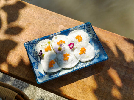 Steamed Coconut Custard or Kanom Tuay. Thai dessert made from rice flour, coconut milk and sugar steamed in small ceramic cups with pandan leaves and coconut milk poured over it. Top viewの写真素材