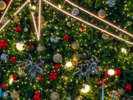 Background, a glowing Christmas tree decorated with red and gold baubles ornaments perfectly captures the joyful spirit of the holiday season.の写真素材