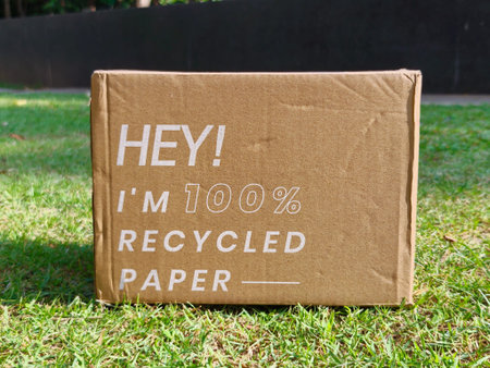 Cardboard boxes made from recycled paper are placed on the grass, reflecting an environmentally friendly concept.の写真素材