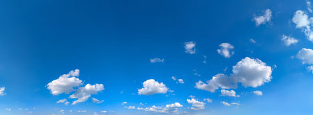 A line of clouds follows the horizon line. Wind movement and good weather. Confidence in the future. Serenity and positivity. Beautiful blue sky background with cloud. Wide banner with copy space for textの写真素材