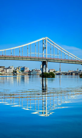 Cable-stayed bridge with its support reflected in the river waves. Cityscape on a summer morning....