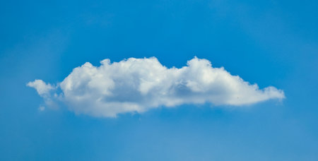 A fluffy cloud like a whipped pillow of cream. Horizontal composition of a long, wide island of...