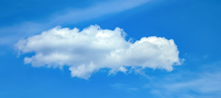 A fading, dissolving feather cloud. A cirrus clouds against a blue background. Light fluffy texture...
