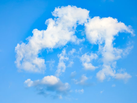 Cirrus cloud structures fly overhead against a clear blue sky. Soft, wispy clouds, evoking peace and freedom.の写真素材