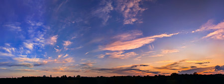 Scenic view of beautiful sunset above summer evening with cloudy sky background. Soft quiet landscape. Water reflection orange sun and purple clouds.の写真素材