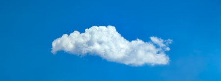 Beautiful cloudscape of nature single white cloud on blue sky background in daytime. Fabulous swirling water vapors. Multi-tiered clouds of steamの写真素材