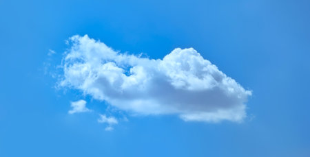 A light cloud hovering above the ground on a blue background. Looking up at the sky. Gradual sailing...