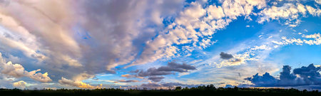 Sunset with sun and clouds on blue and orange dramatic sky with sun rays. A stroll along the forest...