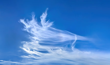 Dynamic diagonal composition banner with copy space inscription. Blue cirrus sky filled many white feather clouds creating a peaceful and inspiring natural landscape scene.の写真素材