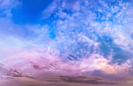 An pink evening sky at sunset. Flattened flakes of cloud against a violet and blue sky. The sun's farewell is reflected calm waters of the river. A serene landscape of peace and elemental energies.の写真素材