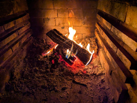A blazing fire for cooking. The red coals are dying down in the oven. The heat is necessary for roasting meat and vegetables. Flame fire smoke warm ash.の写真素材