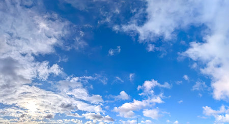 Blue sky with white clouds. The sky is clear and bright. Some many cloud cirrus cumulus groups on blue background. Gorgeous steam cold view.の写真素材