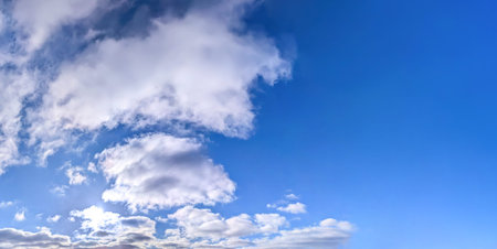 Banner with a pronounced diagonal composition and empty space for your text. A stream of clouds slowly follows the sky. Windy weather of a beautiful day. Cover for a website or mobile application. Sitting giant cotton wool flow.の写真素材