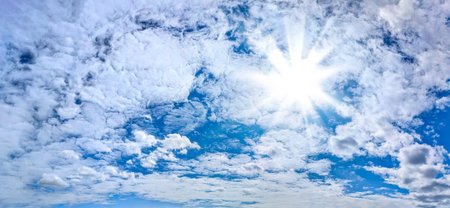 Sun with blue sky nature background. Many Detailed clouds cumulus and cirrus fully covered space of wide banner. Light sunny day wuth ray of power summer warm energy.の写真素材