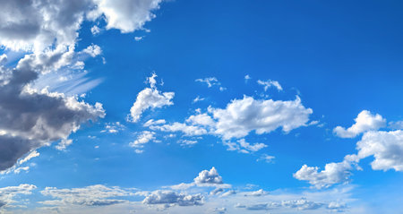 Wide panorama composition banner with copy space. Blue cirrus sky filled with many white feather clouds creating a peaceful and inspiring natural landscape scene.の写真素材