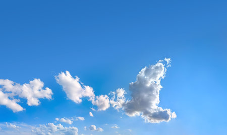 A high-resolution image showcasing a vibrant blue sky filled with scattered white cumulus clouds. The natural daylight highlights the soft textures of the cloud. Big space for your text.の写真素材