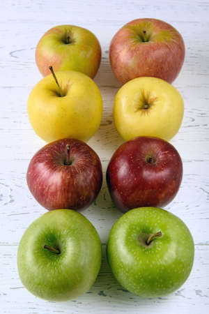 Six multicolored apples on a white wooden backgroundの写真素材