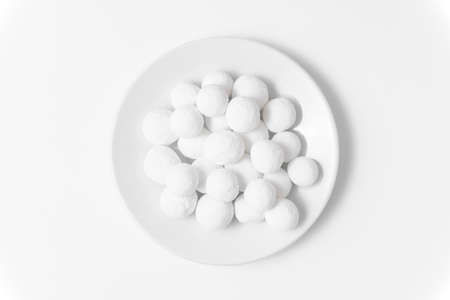 White sugar balls in a white saucer on a white background. close up view.の写真素材