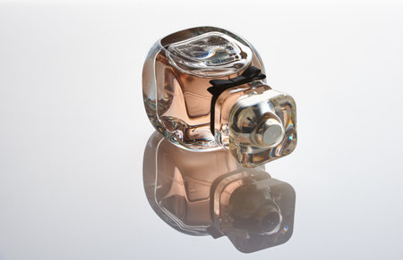 Eau de parfum Givenchy Very Irresistible Rose Damascena lies on a white mirror background. reflection, gradient.のeditorial素材