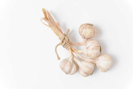 A bunch of five garlic tied with twine on a white background. close up view.の写真素材