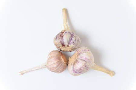 Three heads of fresh organic garlic isolated on a white background. Close up, top view.の写真素材