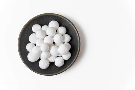 White delicious sugar balls in a gray plate isolated on a white background. Close up, top view.の写真素材