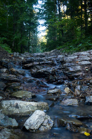 Mountain river flows between picturesque summer stones. Rocks in the mountains with water flowingの写真素材
