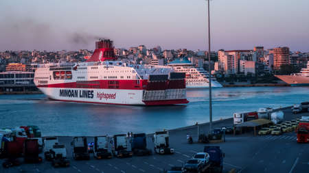 Athens - Greece - 29 - July - 2020: Feryboat on the sea in the port and city in the backgroundのeditorial素材