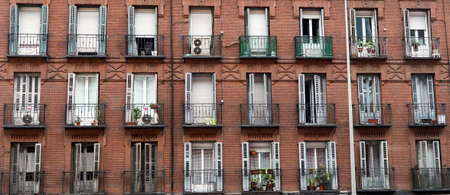 Red brick facade with wrought iron balconies in Madrid, Spainの写真素材