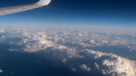 Cloudscape from airplane window. Clouds from above with airplane wingの写真素材