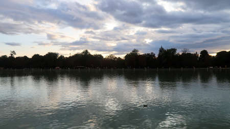 Trees and clouds reflecting in the water in Buen Retiro Park Madridの写真素材