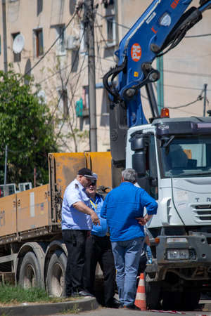Iasi, Romania, 7th June 2021: Three middle-aged men talking near a vehicle in Iasi, Romaniaのeditorial素材