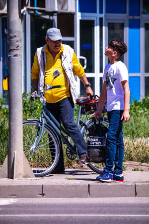 Iasi, Romania, 7th June 2021: A young boy walking with his grandfather on his bike in Iasi, Romaniaのeditorial素材