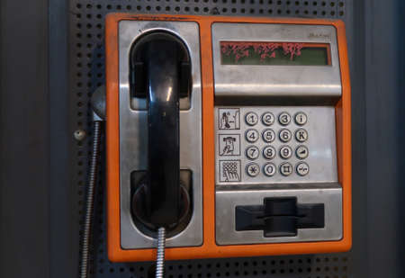 Front view of orange public phone in good condition with selective focus