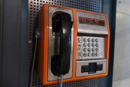 Front view of orange public phone in good condition with selective focusの写真素材