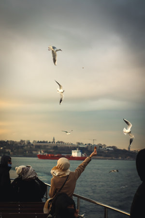 istanbul, Turkey, 2nd of January 2022 - People feeding pigeons while taking public transportation...